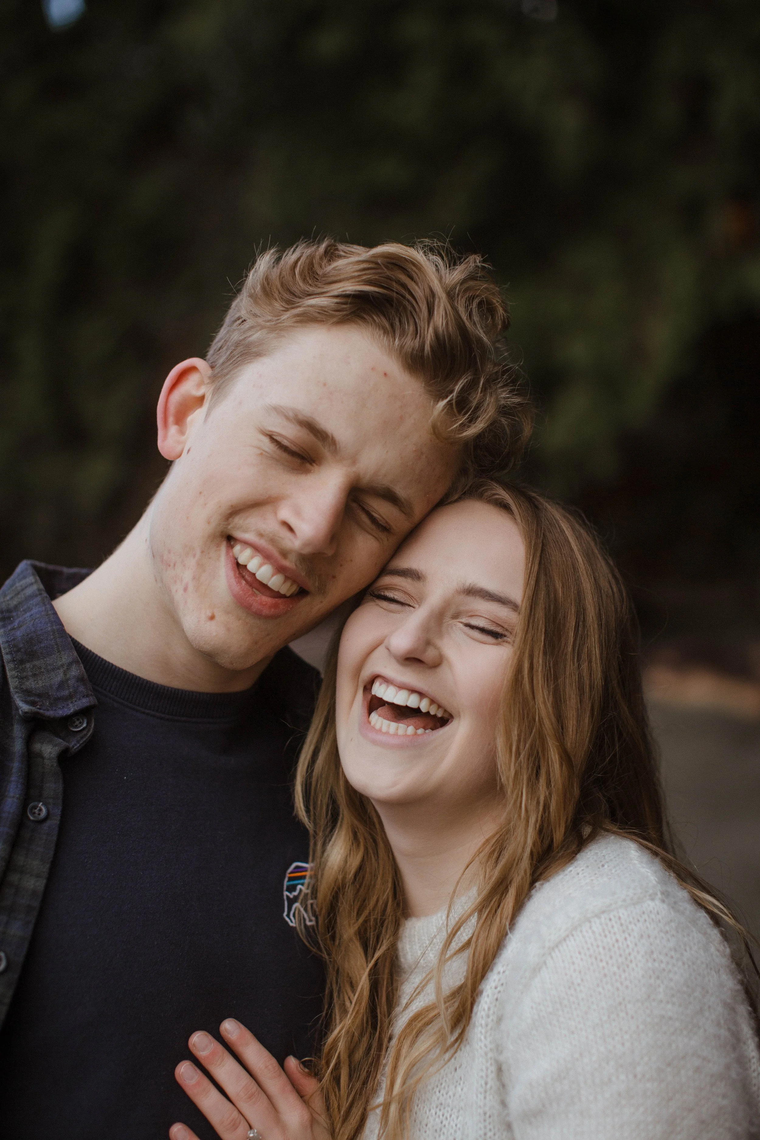 couple laughing on the beach in bellingham