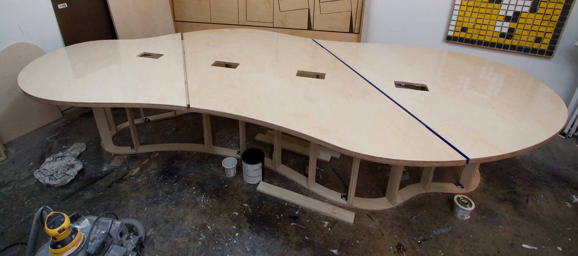  13' long cloud shaped maple Europly&nbsp;conference table for Ben &amp; Jerry's in St Albans. Corrugated metal base hides wires for 4 power/data consoles. 
