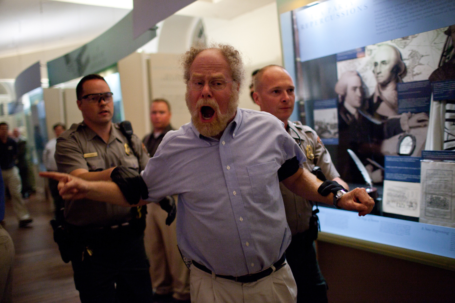 Boston, Mass. - A man who attempted to place former Secretary of Defense Donald Rumsfeld under citizens arrest is escorted out during Rumsfeld's event at the Old South Meeting House.
