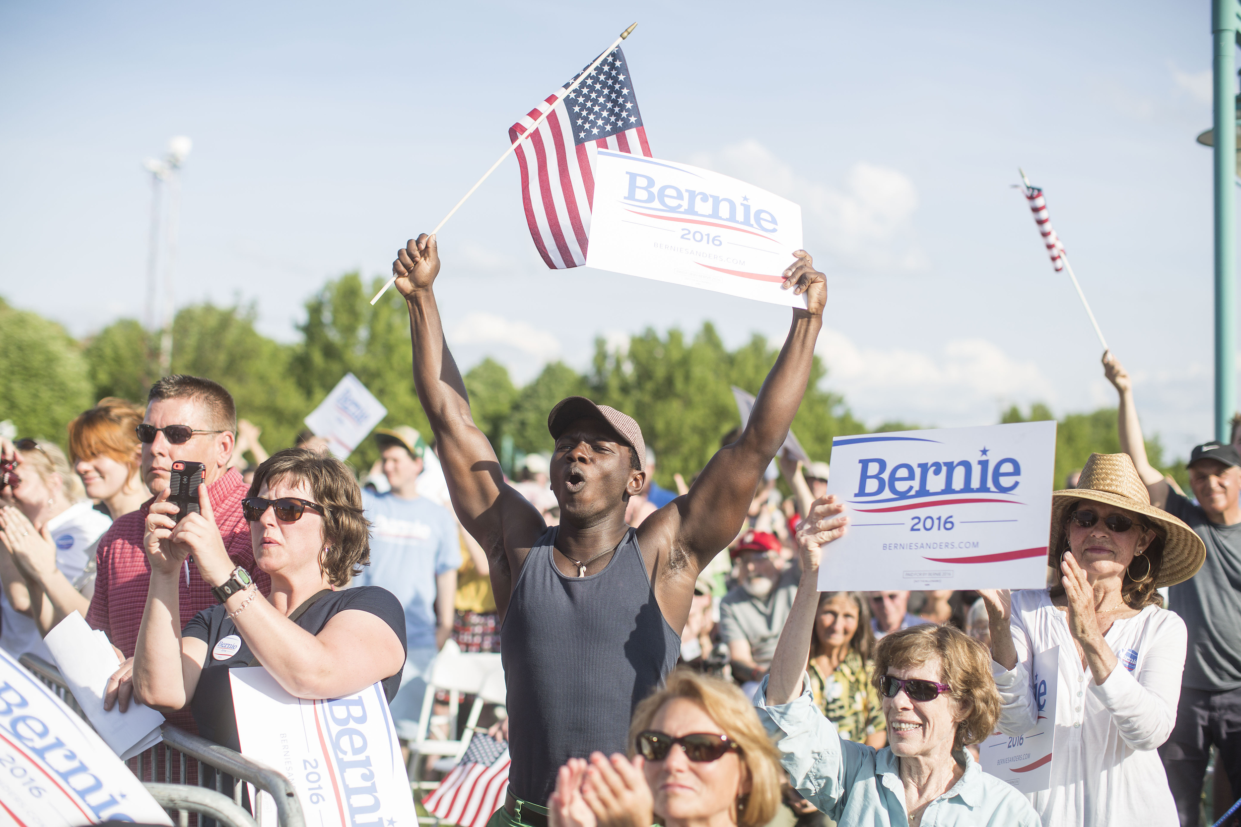   Supporters cheer while holding up signs and U.S. flags during the official kickoff to Senator Bernie Sanders' presidential campaign in Burlington, Vermont, U.S., on Tuesday, May 26, 2015. Shortly after declaring himself a presidential candidate, Sa