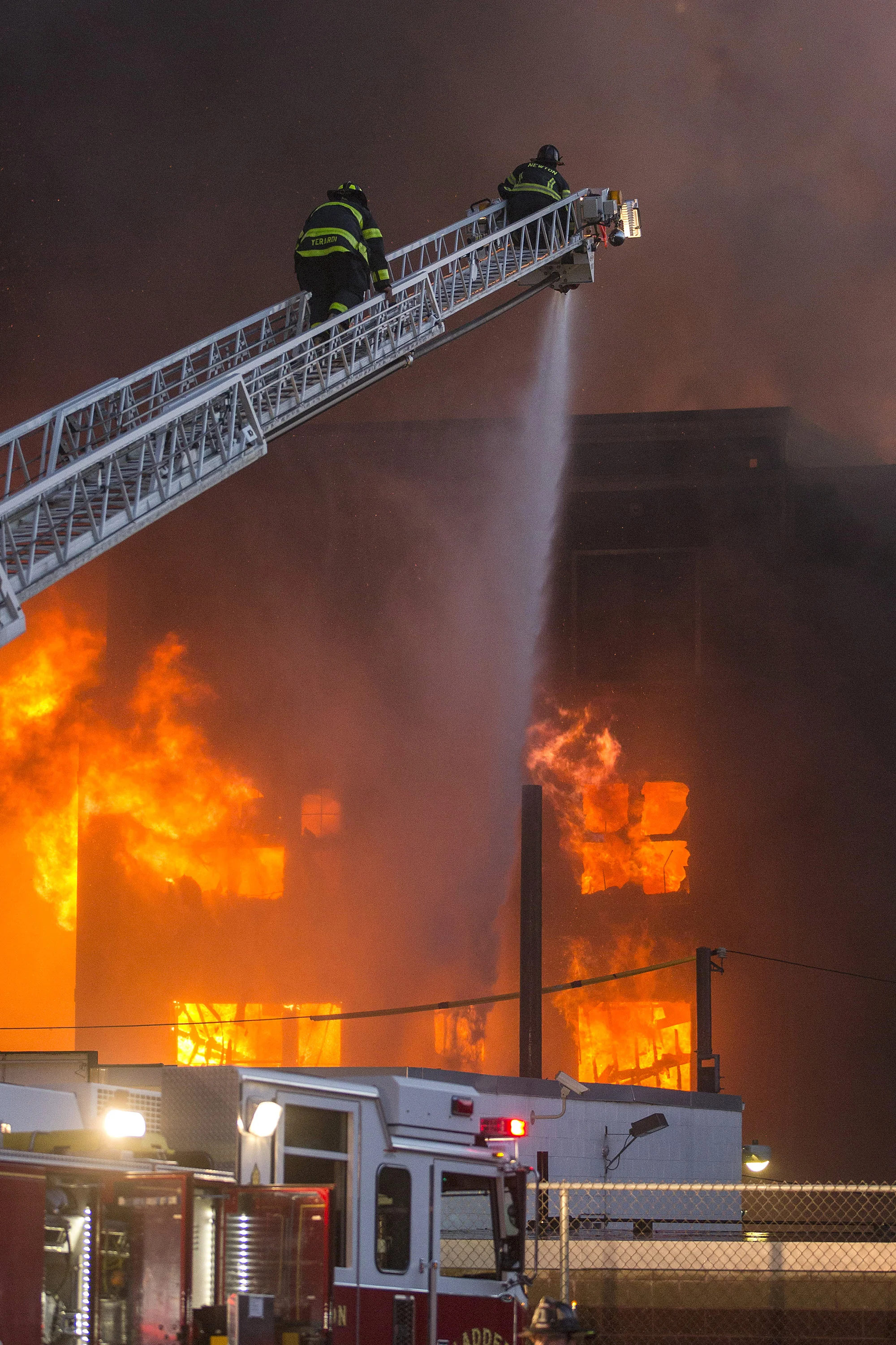  Firefighters put water on a fully involved building at the scene of an 8 alarm fire in Waltham on Sunday, July 23, 2017 that involved multiple structures. (Scott Eisen for The Boston Globe) 
