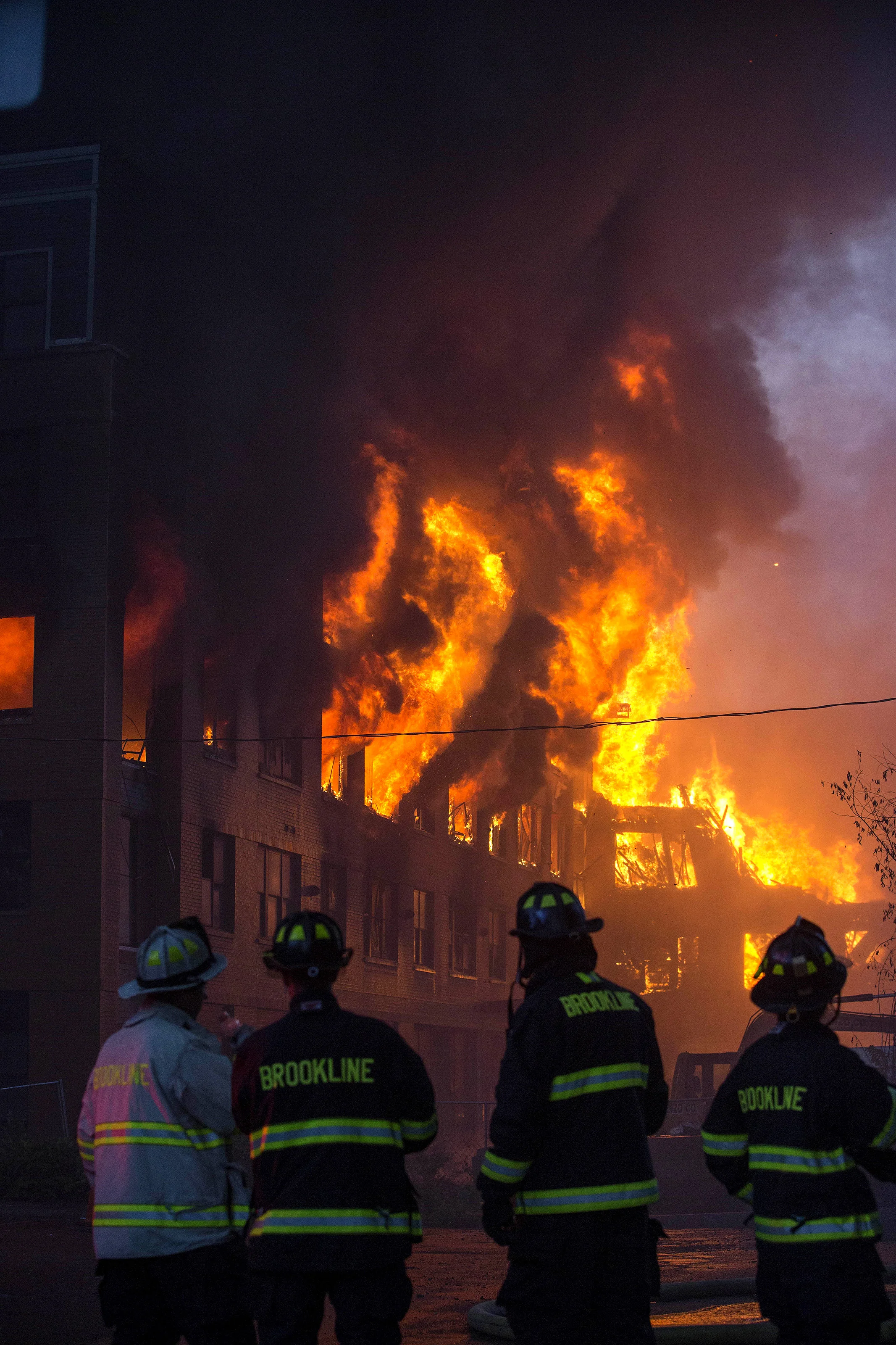  Firefighters watch as a building burns at the scene of an 8 alarm fire in Waltham on Sunday, July 23, 2017 that involved multiple structures. (Scott Eisen for The Boston Globe) 