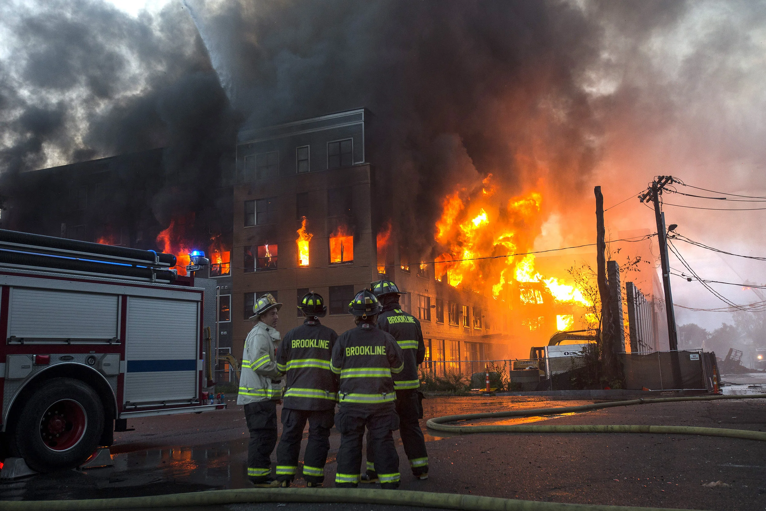  Firefighters watch as a building burns at the scene of an 8 alarm fire in Waltham on Sunday, July 23, 2017 that involved multiple structures. (Scott Eisen for The Boston Globe) 
