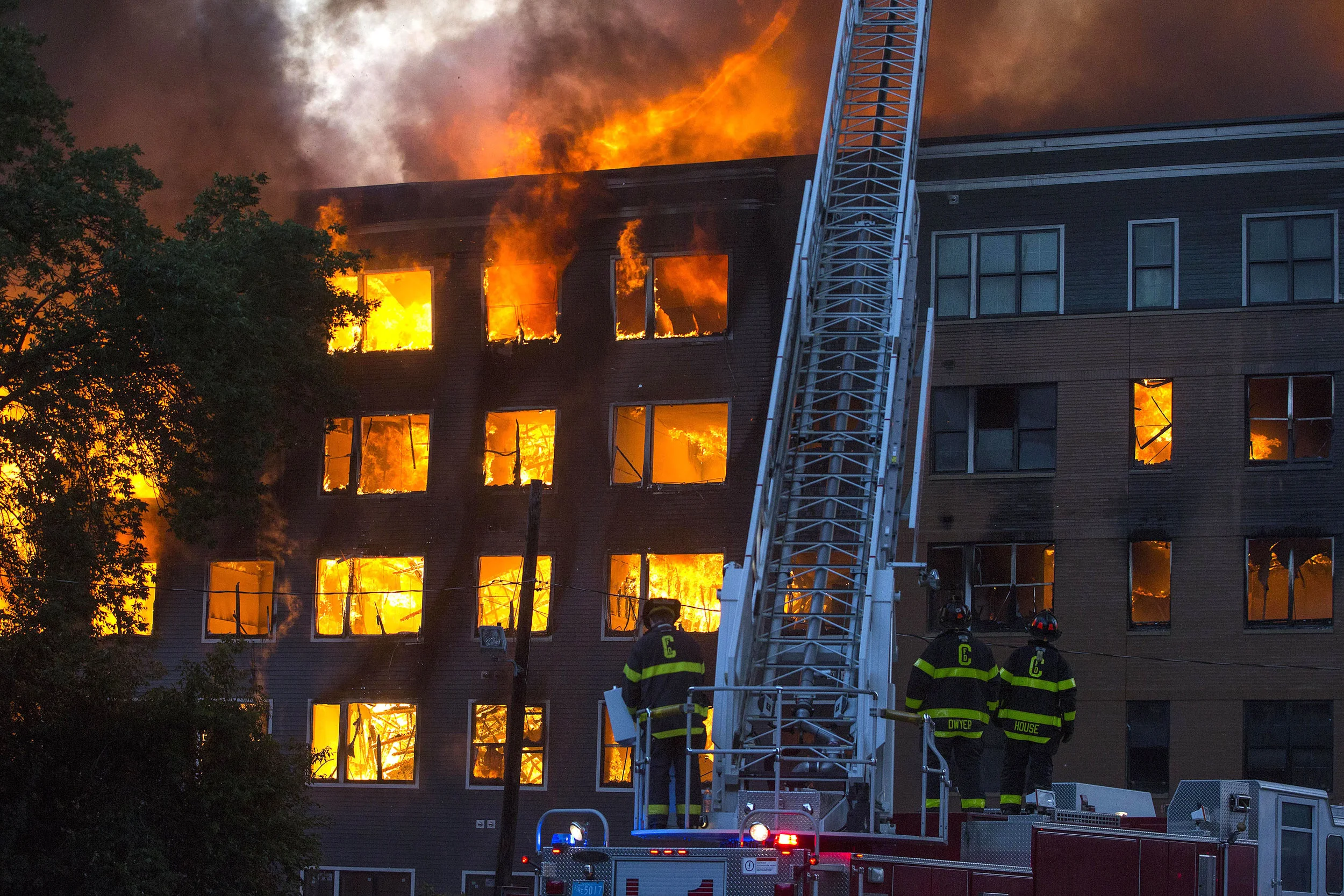  Cambridge firefighters watch as fire and smoke pours from a fully involved building at an 8-alarm fire where multiple buildings were fully involved in Waltham on Sunday, July 23, 2017. (Scott Eisen for The Boston Globe) 