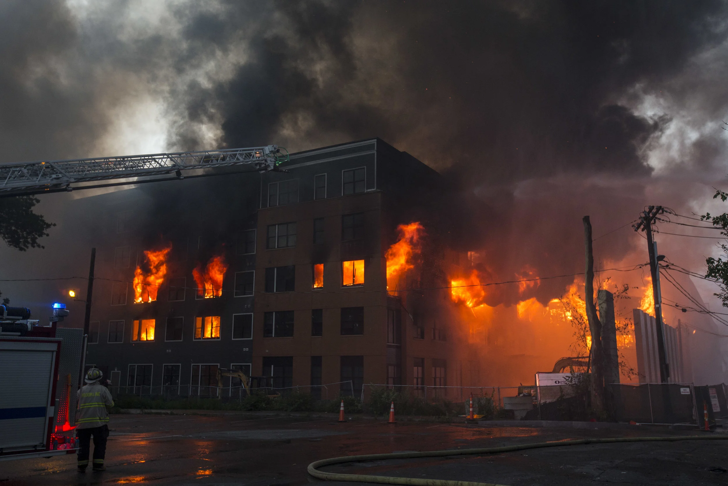 Fire pours from a building at an 8 alarm fire in Waltham on Sunday, July 23, 2017 that involved multiple structures. (Scott Eisen for The Boston Globe)