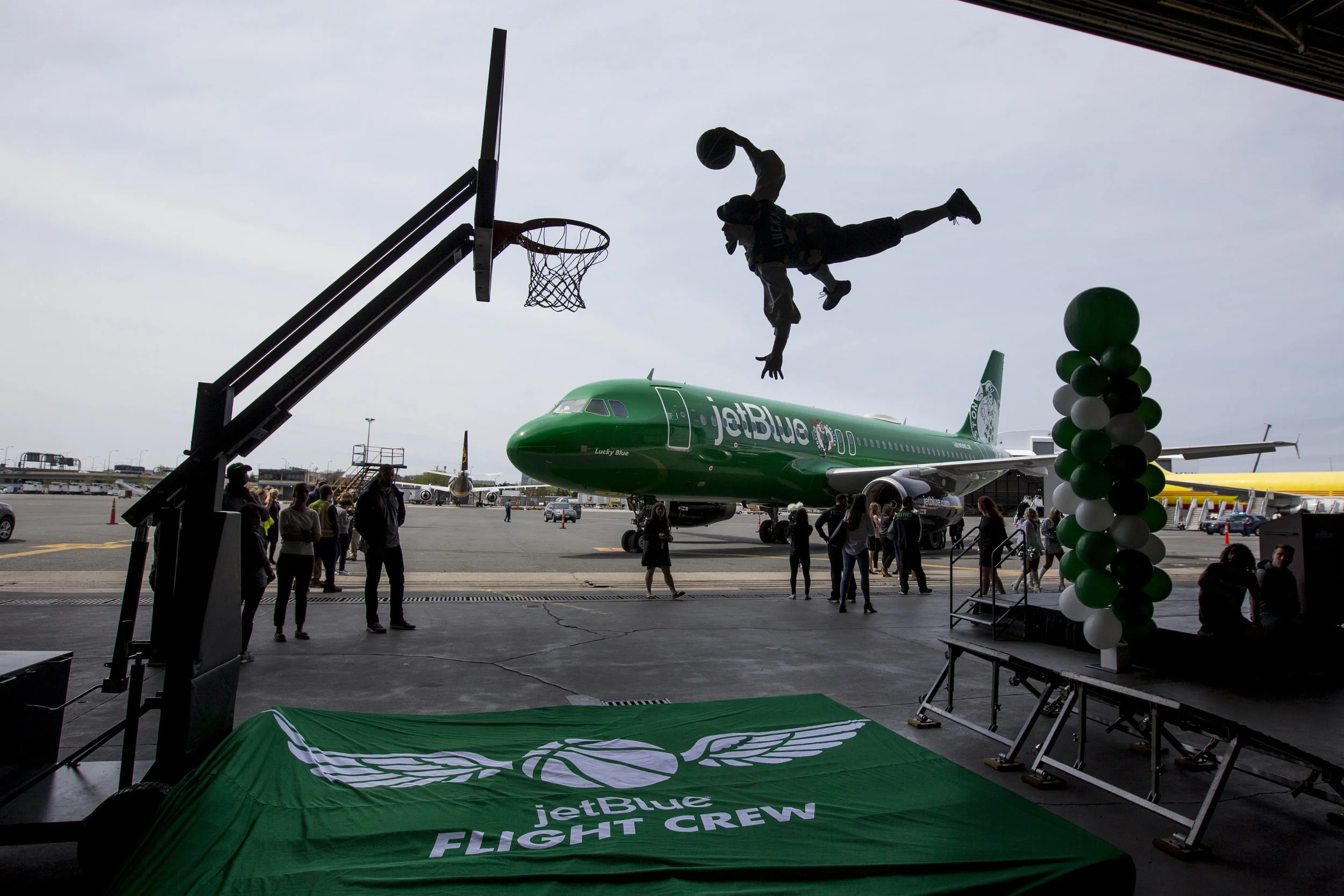  Boston, Mass. - Boston Celtics’ mascot Lucky the Leprechaun does a dunk in front of the new JetBlue Celtics branded jet inside of the JetBlue hangar at Logan International Airport on Monday, May 7th, 2018.  