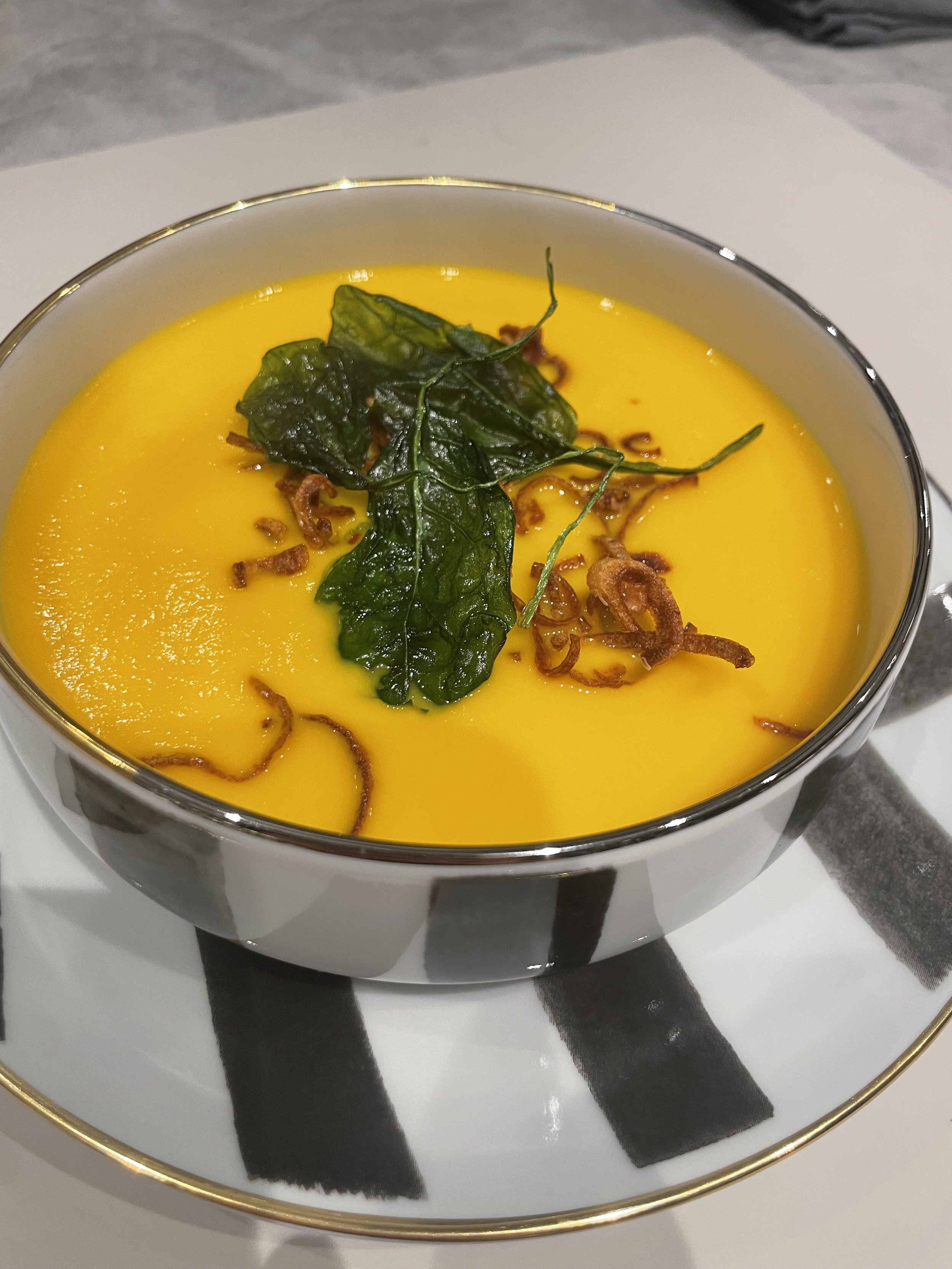 gingered butternut squash soup with confit shallots and crispy spinach