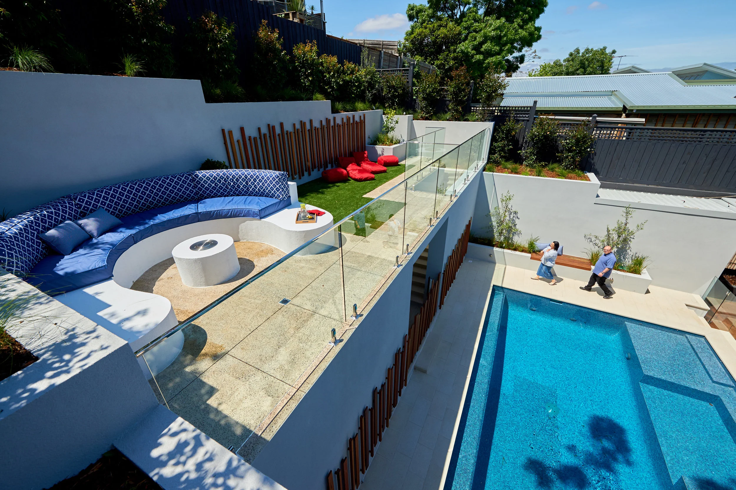 The family terrace is a wonderful place to relax, to lie in the sun, and to call down to the swimmers below. The timber detail is echoed on the upper wall, again to break up all of the rendered wall space.