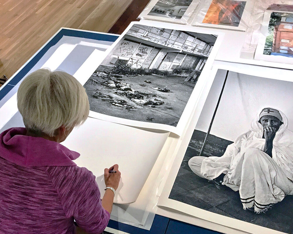  artist signing photographic prints 