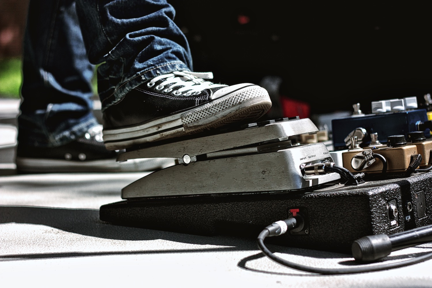 Tallahassee, FL, USA – March 29, 2014: Guitarist wearing Converse Chuck Taylors with his foot on a Dunlop Volume pedal at an outdoor performance.
