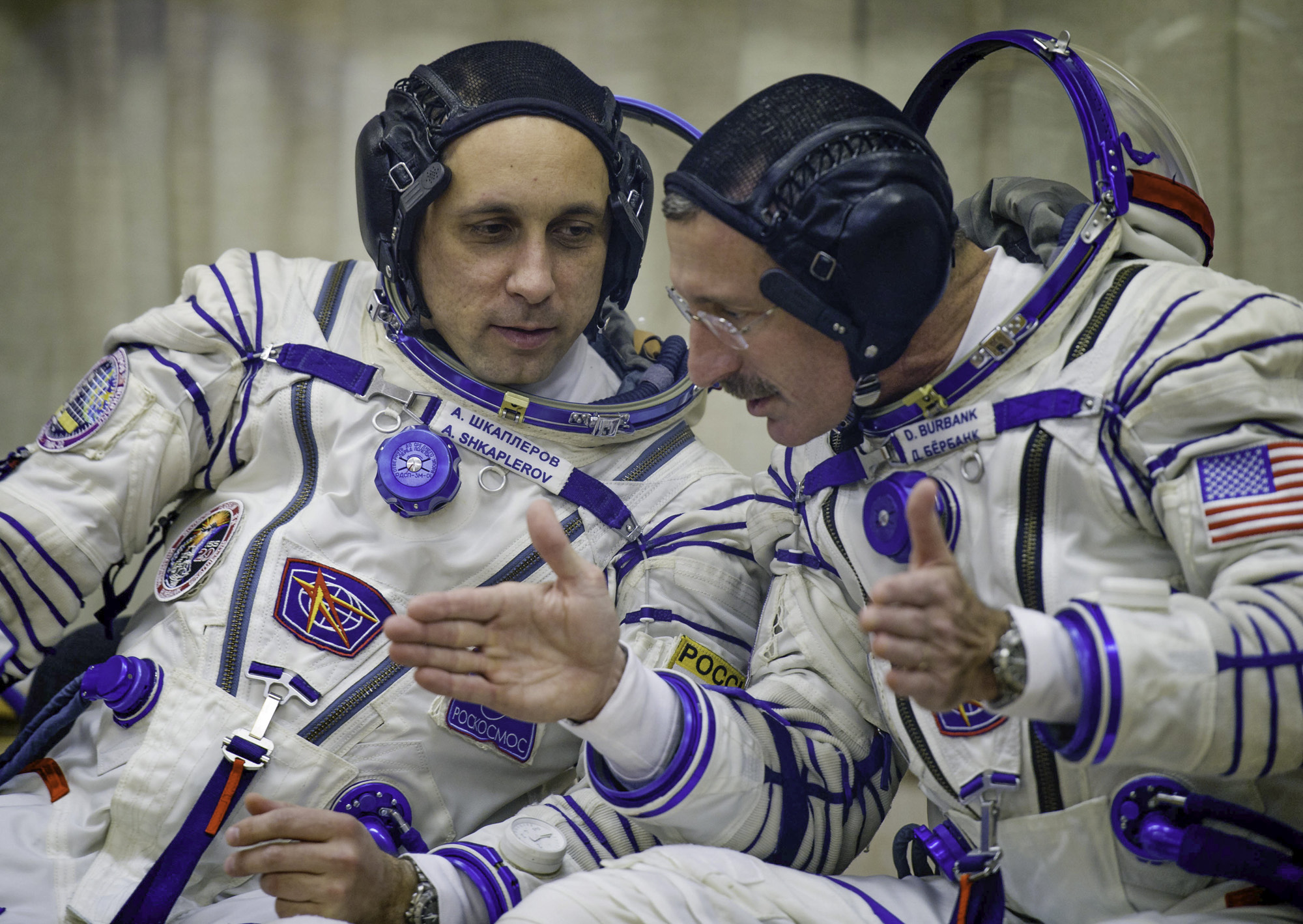  Expedition 29 NASA Flight Engineer Daniel Burbank, right, and Expedition 29 Soyuz Commander Anton Shkaplerov share a few words as they wait for their Russian Sokol suits to be prepared for launch to the International Space Station at the Baikonur Co