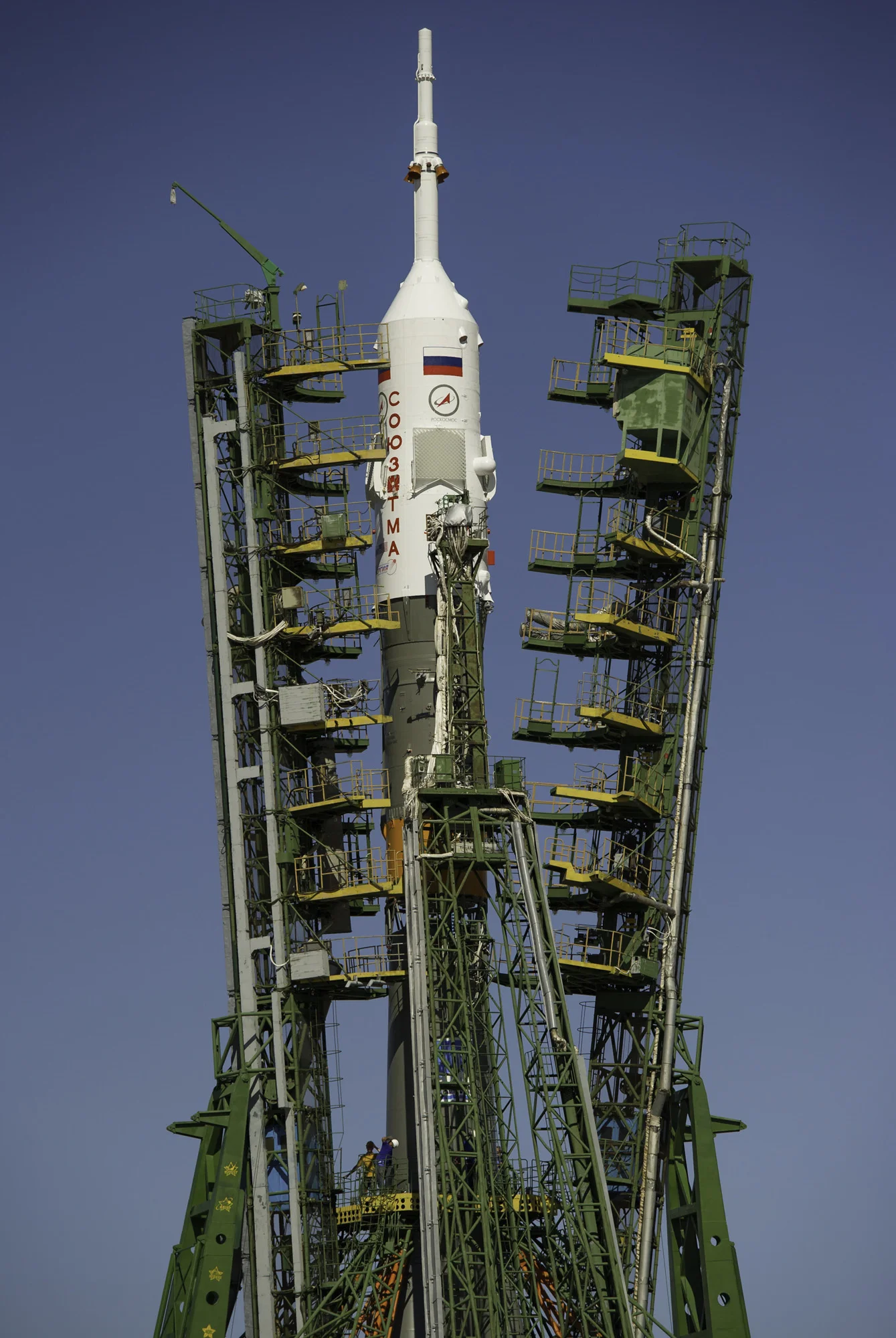 Large gantry mechanisms on either side of the Soyuz TMA-205M spacecraft are raised into position to secure the rocket at the launch pad on Thursday, July 12, 2012 at the Baikonur Cosmodrome in Kazakhstan. (NASA/Carla Cioffi)