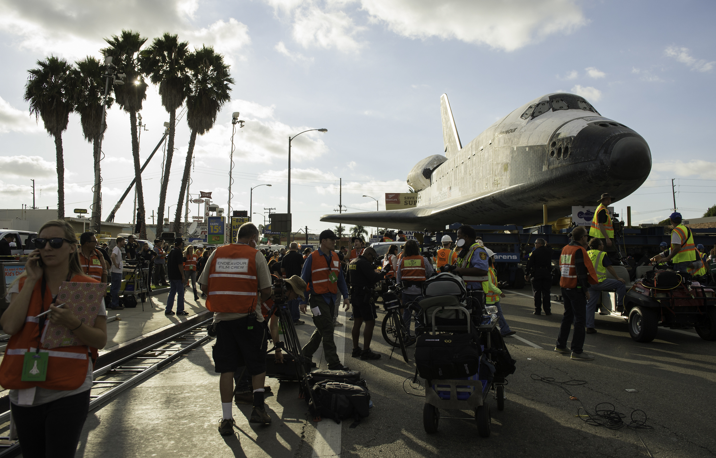 Support personnel and film crews are seen working around the space shuttle Endeavour as it traverses through Inglewood, Calif. on Friday, Oct. 12, 2012. Endeavour, built as a replacement for space shuttle Challenger, completed 25 missions, spent 299