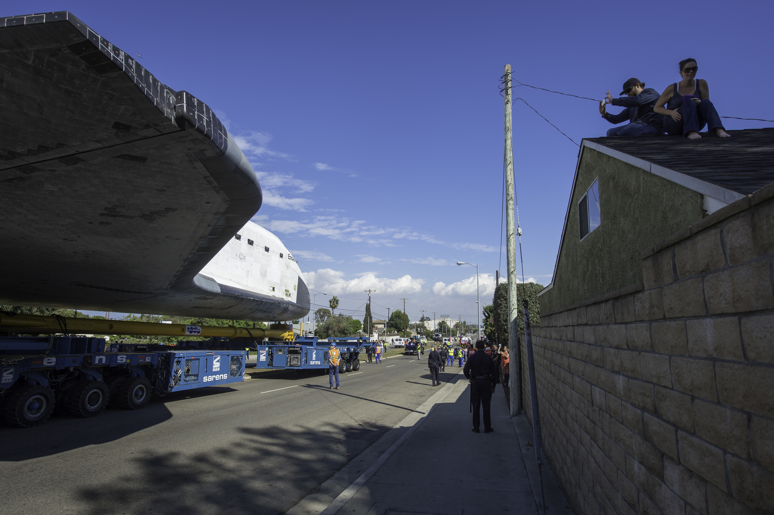 A spectator on the roof of a building photographs space shuttle Endeavour as it passes by on its way to its new home at the California Science Center in Los Angeles, Friday, Oct. 12, 2012. Endeavour, built as a replacement for space shuttle Challeng