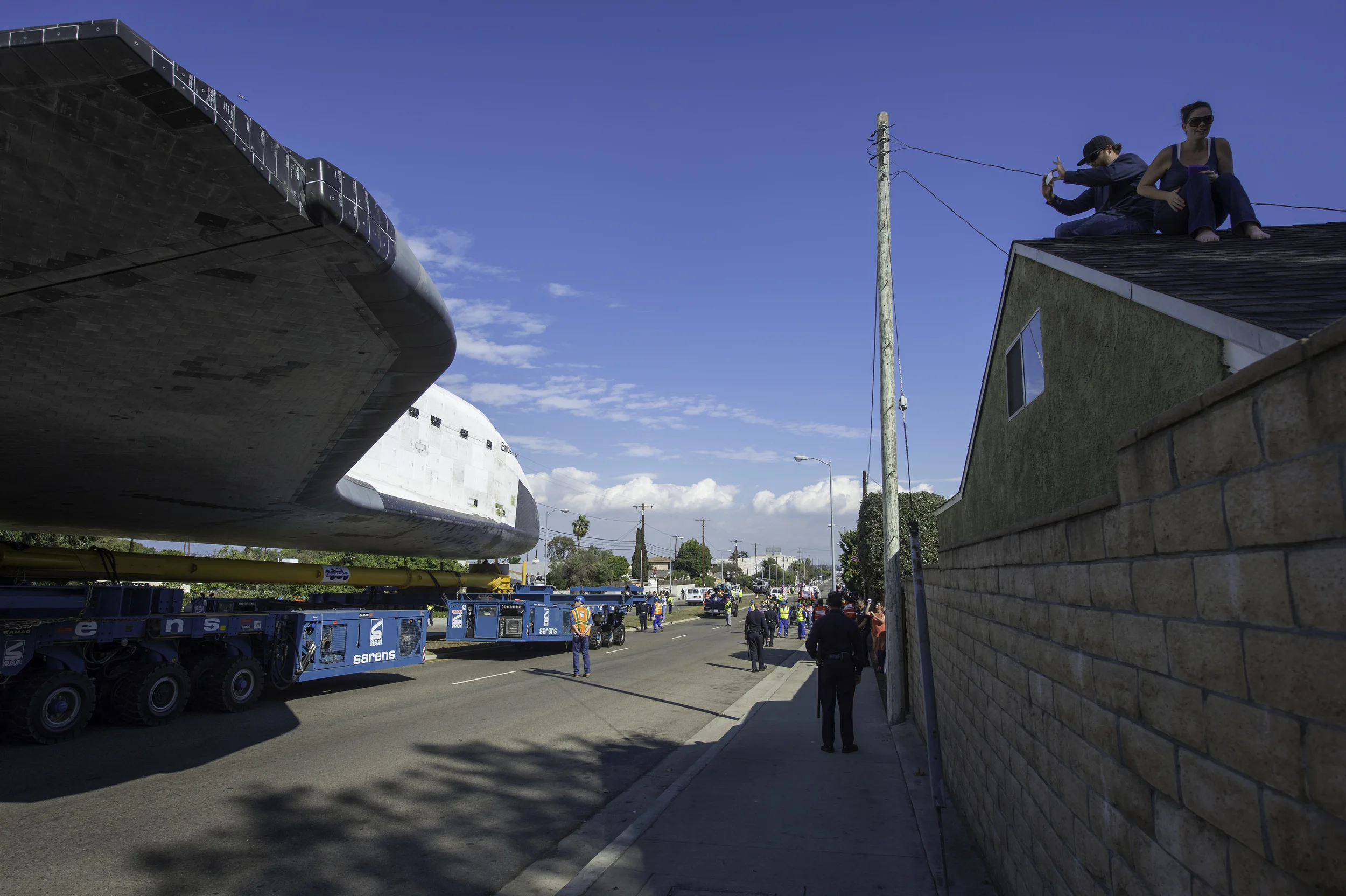 A spectator on the roof of a building photographs space shuttle Endeavour as it passes by on its way to its new home at the California Science Center in Los Angeles, Friday, Oct. 12, 2012. Endeavour, built as a replacement for space shuttle Challenger, completed 25 missions, spent 299 days in orbit, and orbited Earth 4,671 times while traveling 122,883,151 miles. Beginning Oct. 30, the shuttle will be on display in the CSC’s Samuel Oschin Space Shuttle Endeavour Display Pavilion, embarking on its new mission to commemorate past achievements in space and educate and inspire future generations of explorers. (NASA/Carla Cioffi)