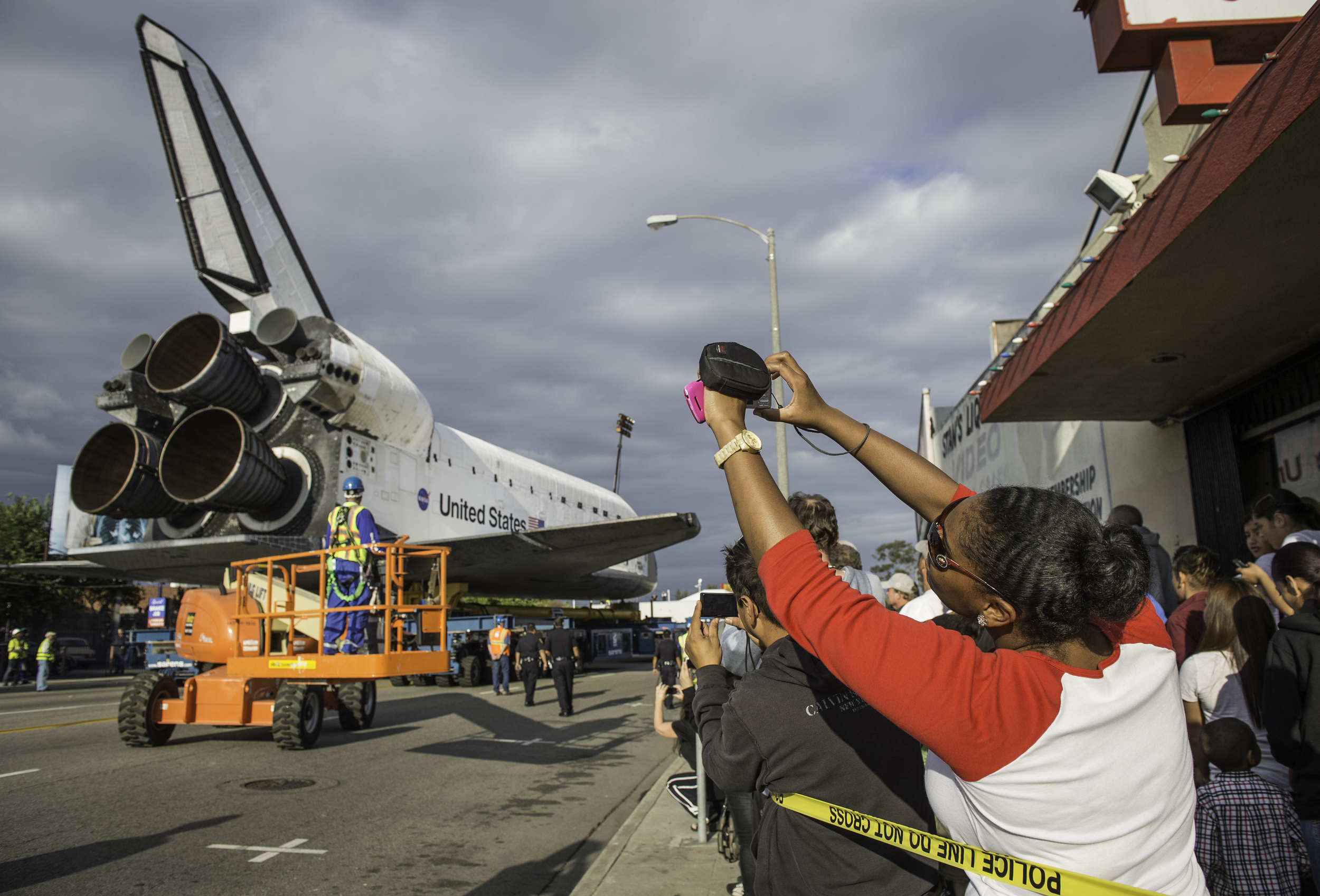 Spectators are seen photographing space shuttle Endeavour as it passes by on its way to its new home at the California Science Center, Friday, Oct. 12, 2012, in Inglewood. Endeavour, built as a replacement for space shuttle Challenger, completed 25