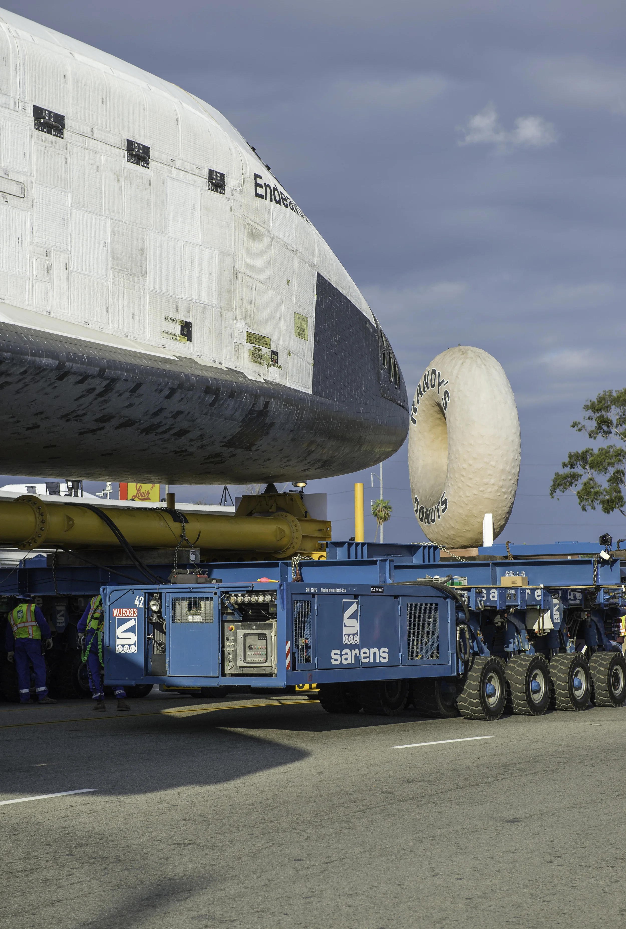 The nose cone of the space shuttle Endeavour is seen next to the Randy’s Donuts landmark in Inglewood, California, Friday, Oct. 12, 2012. Endeavour, built as a replacement for space shuttle Challenger, completed 25 missions, spent 299 days in orbit, and orbited Earth 4,671 times while traveling 122,883,151 miles. Beginning Oct. 30, the shuttle will be on display in the CSC’s Samuel Oschin Space Shuttle Endeavour Display Pavilion, embarking on its new mission to commemorate past achievements in space and educate and inspire future generations of explorers. (NASA/Carla Cioffi)
