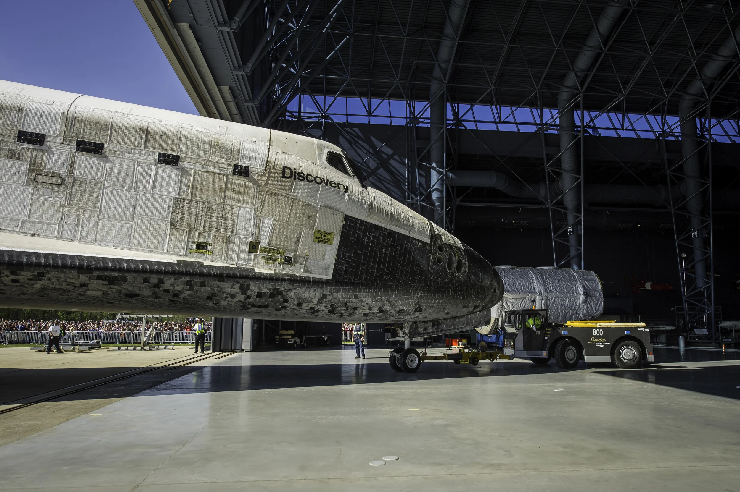 Space shuttle Discovery is rolled into its hangar at the Steven F. Udvar-Hazy Center Thursday, April 19, 2012 in Chantilly, Va. Discovery will be permanently housed at the Udvar-Hazy Center, part of the Smithsonian Institution’s Air and Space Museum. Discovery, the first orbiter retired from NASA’s shuttle fleet, completed 39 missions, spent 365 days in space, orbited the Earth 5,830 times, and traveled 148,221,675 miles. NASA will transfer Discovery to the National Air and Space Museum to begin its new mission to commemorate past achievements in space and to educate and inspire future generations of explorers. (NASA/Carla Cioffi)