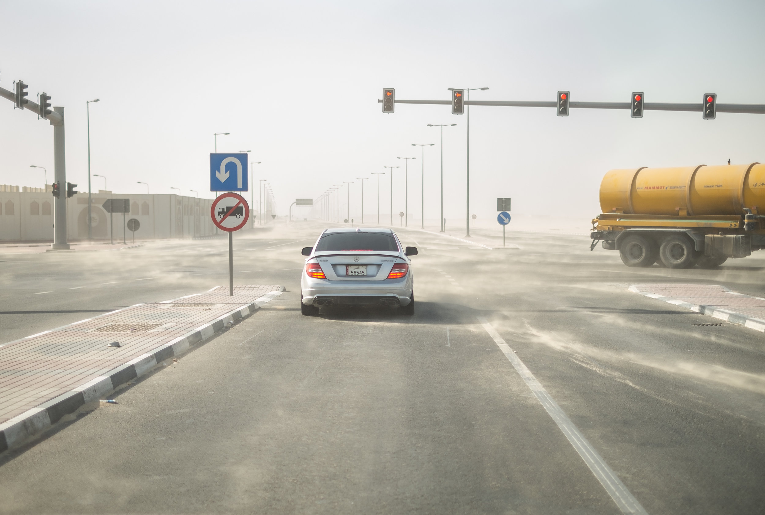  A Mercedes-Benz and a sewage truck are seen in a dust storm on the northern edge of Doha. 