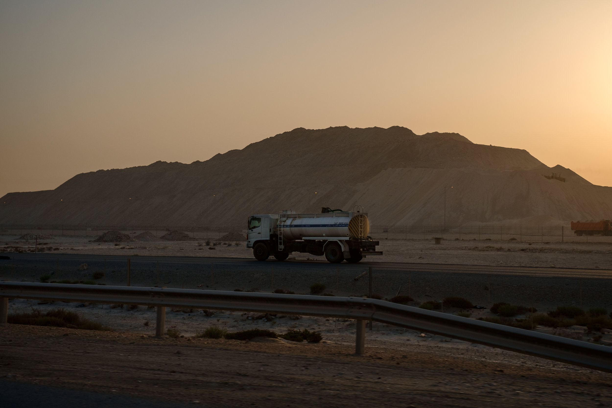  The ubiquitous semi truck, this one carrying water, is seen at sunrise at a massive construction site just north of Lusail City. 