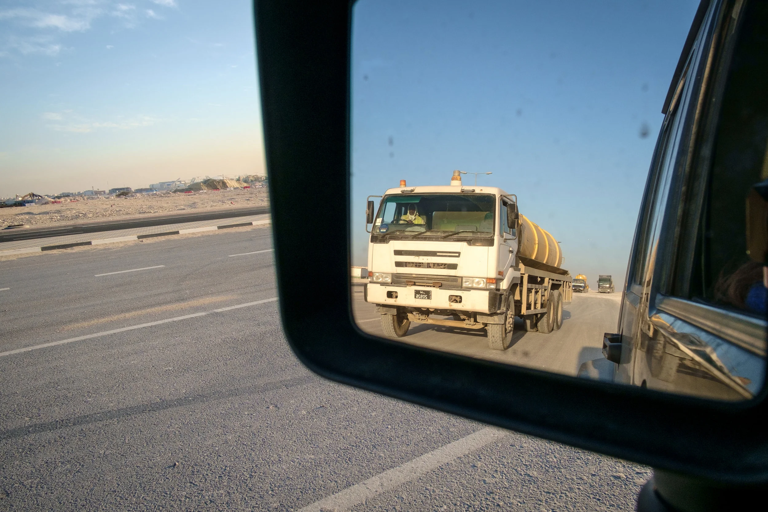 The ubiquitous semi truck is seen at the end of the day leaving a massive construction site on the outskirts of Doha.