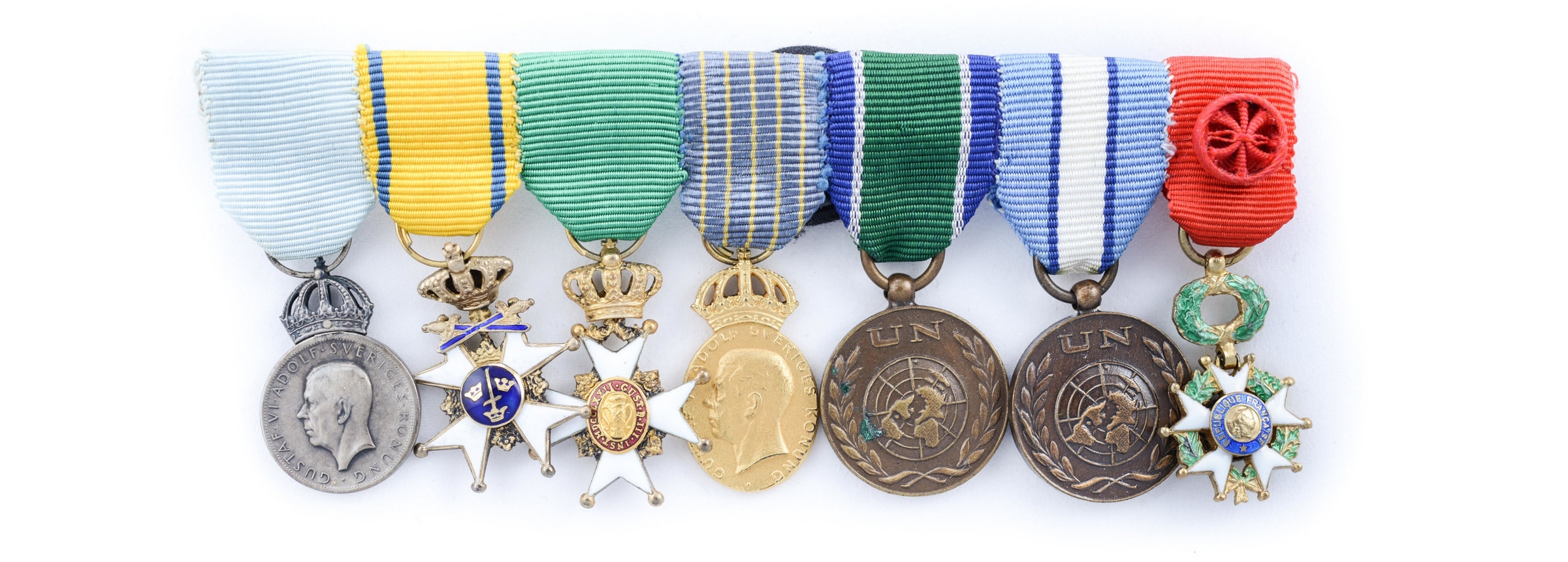 Även överste Waern mottog flera utmärkelser under sin karriär. Bilden visar Waerns miniatyrmedaljer, från vänster Gustav VI Adolfs minnesmedalj i silver med anledning av 85-årsdagen 1967; Svärdsorden; Vasaorden; Hemvärnets kungliga förtjänstmedalj i guld (stämplad 1970); FN-medalj för insatserna i Kongo respektive Cypern samt Franska Hederslegionen. Foto: Probus auktioner, Stockholm.