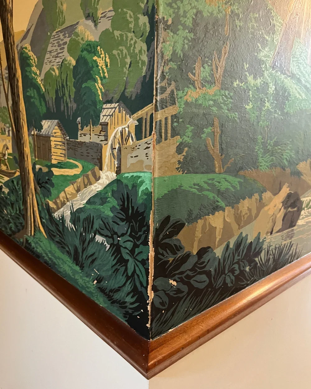 Detail of damaged wallpaper showing flaking paint, cracks, and lifting paper before restoration