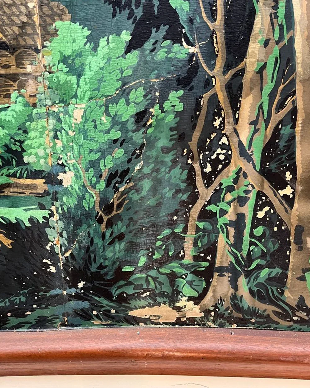 Detail of damaged wallpaper showing flaking paint, cracks, and lifting paper before restoration