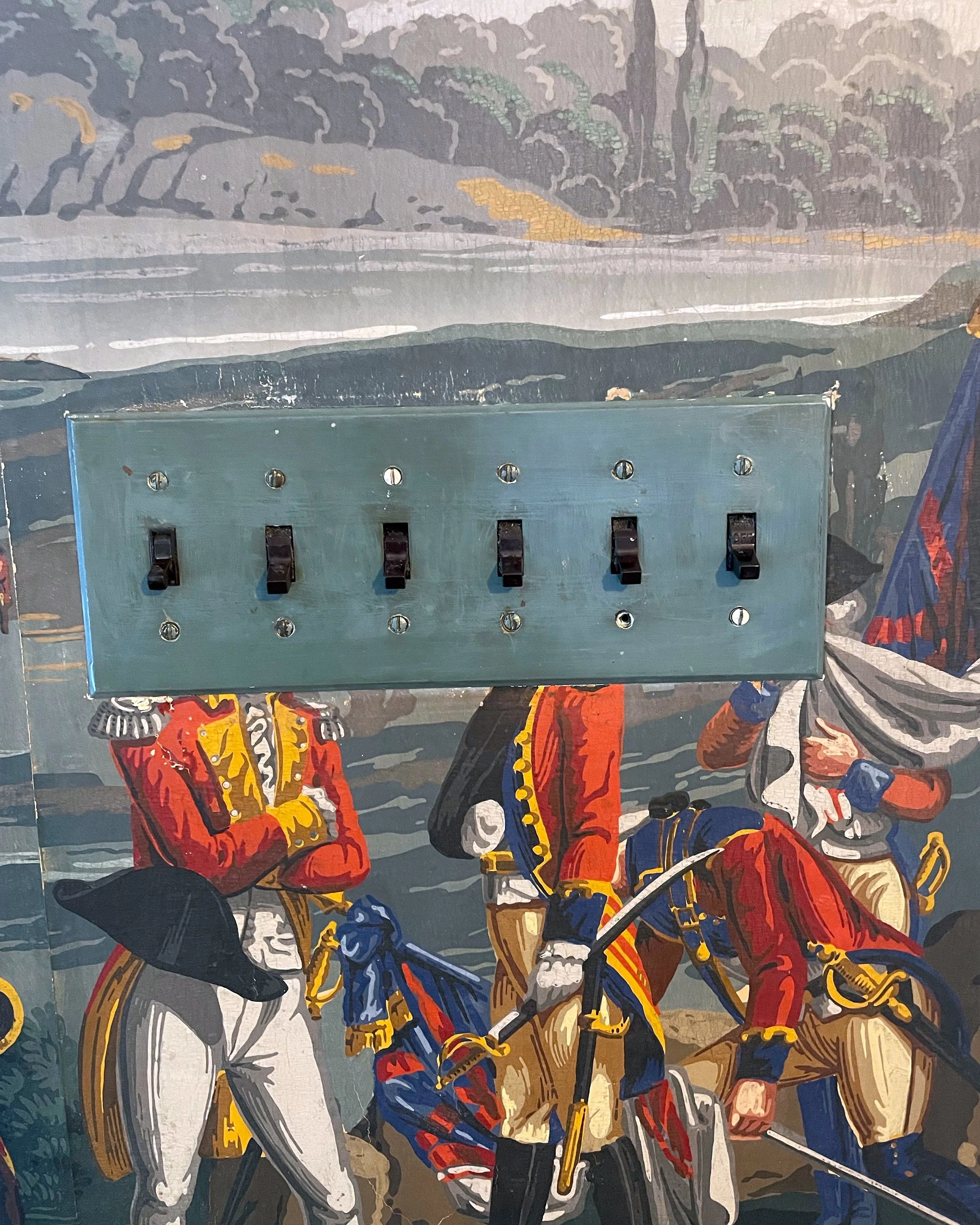 Hand-painted switch plates integrated into scenic wallpaper - before