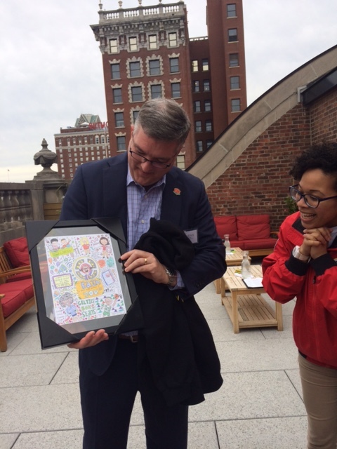Andy Viens receives a thank you gift, a drawing by AmeriCorps Member Theda Tann, as AmeriCorps member Wilmaris Soto looks on