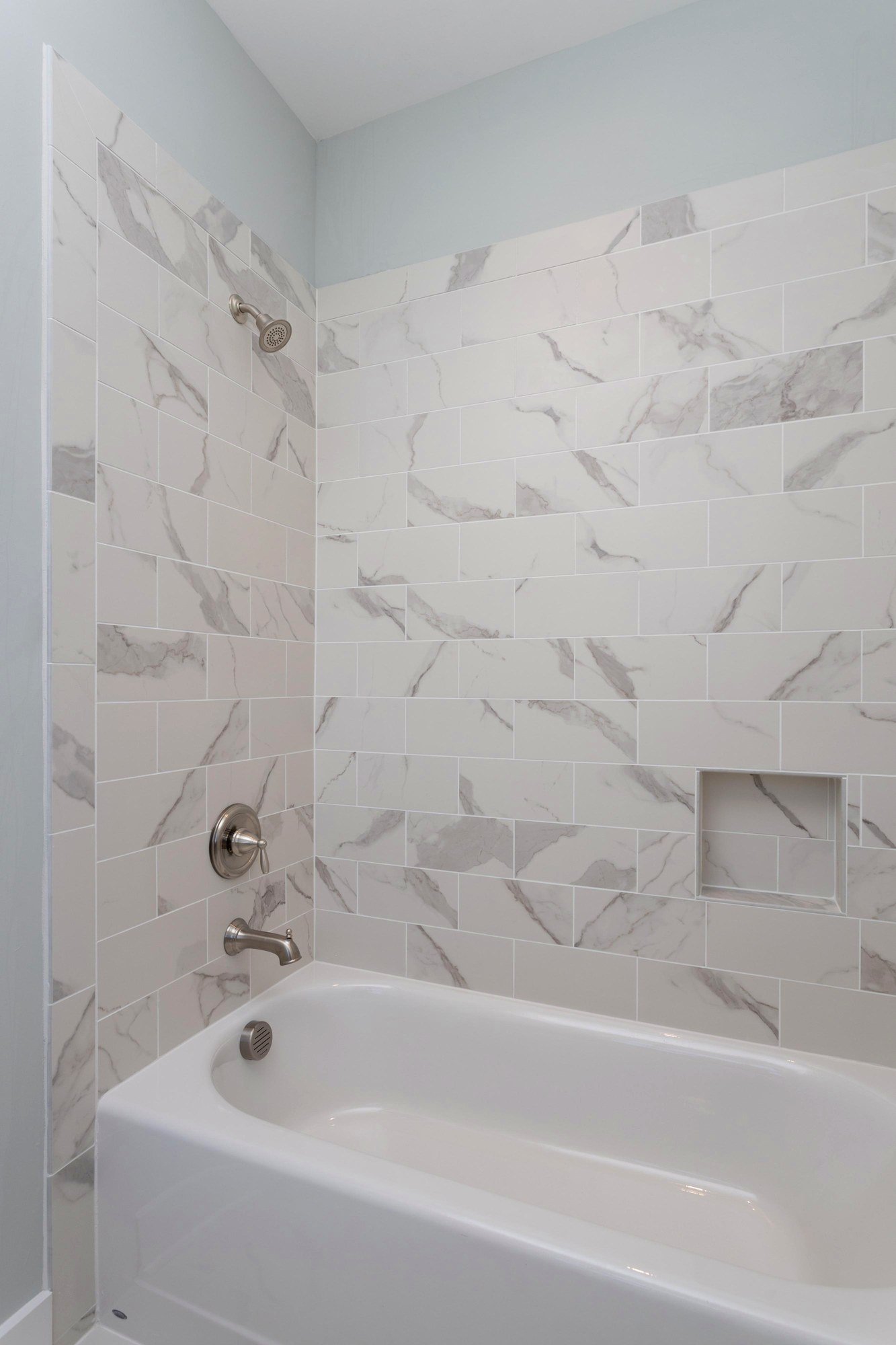 Guest bath with a marble tub and shower surround in a Johns Island SC custom home build
