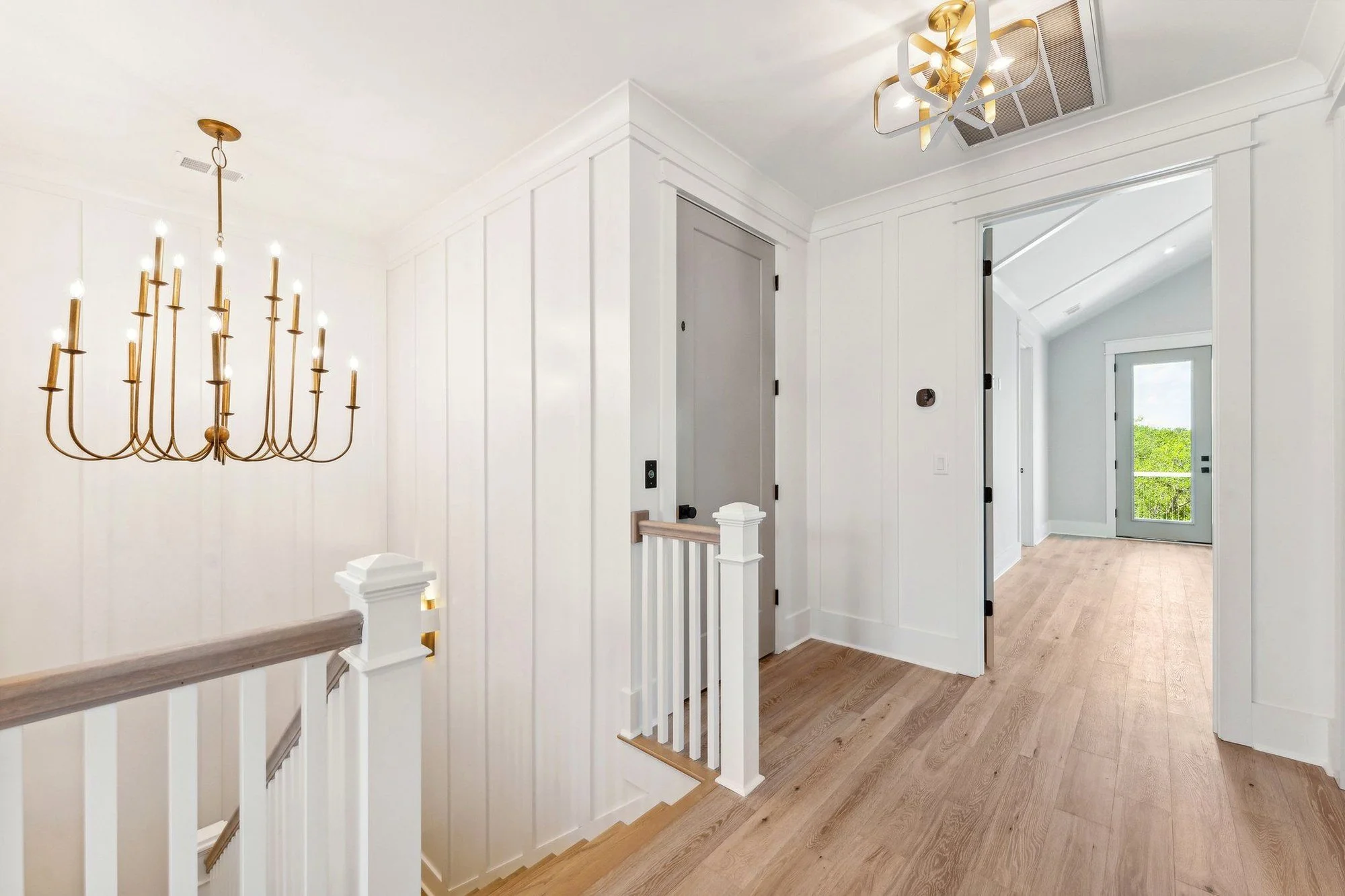 Upstairs landing with brass lighting and white oak floors in a Daniel Island SC home