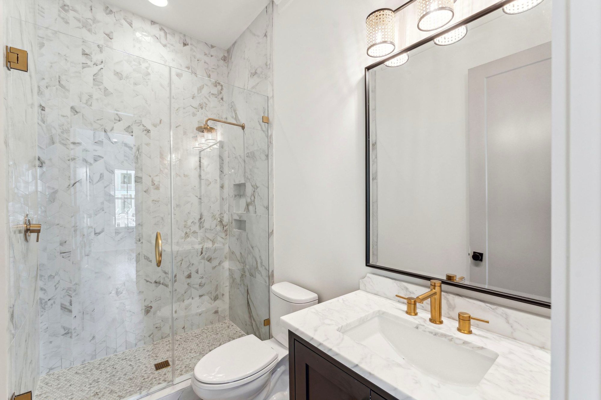 Guest bathroom with marble shower surround and brass fittings in Daniel Island SC
