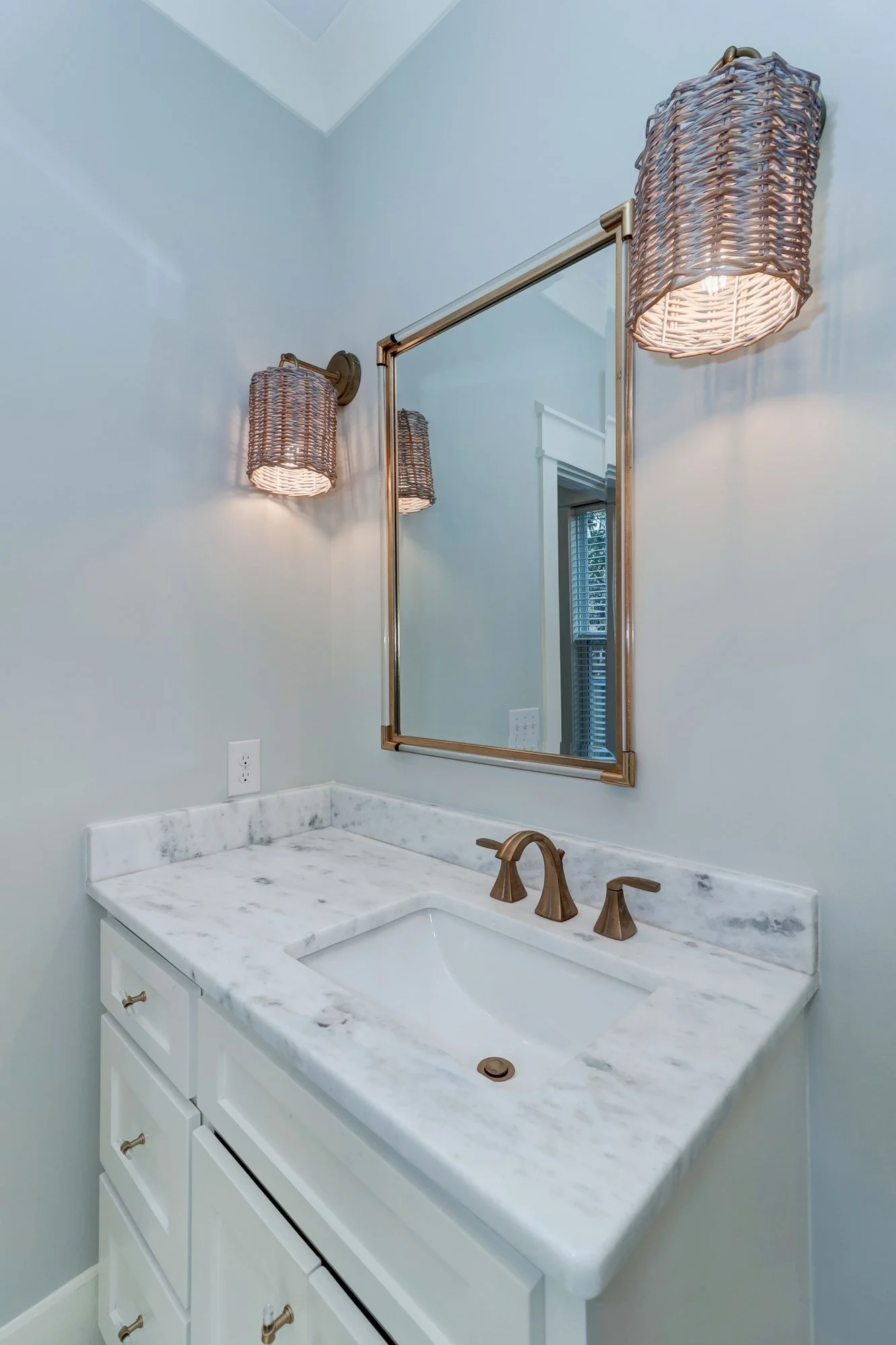 Guest vanity with wicker sconces in an Old Village Mount Pleasant SC custom home build