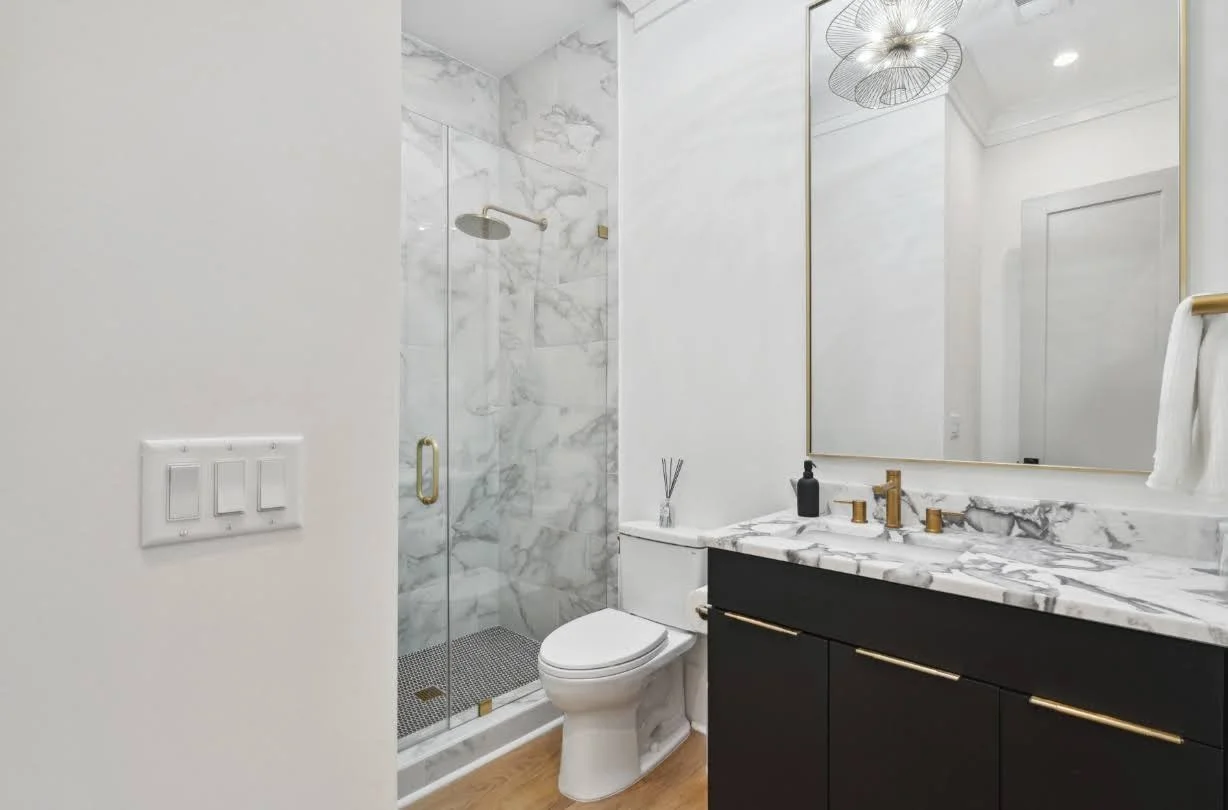Guest bath with marble tile shower in an Isle of Palms SC luxury custom home build