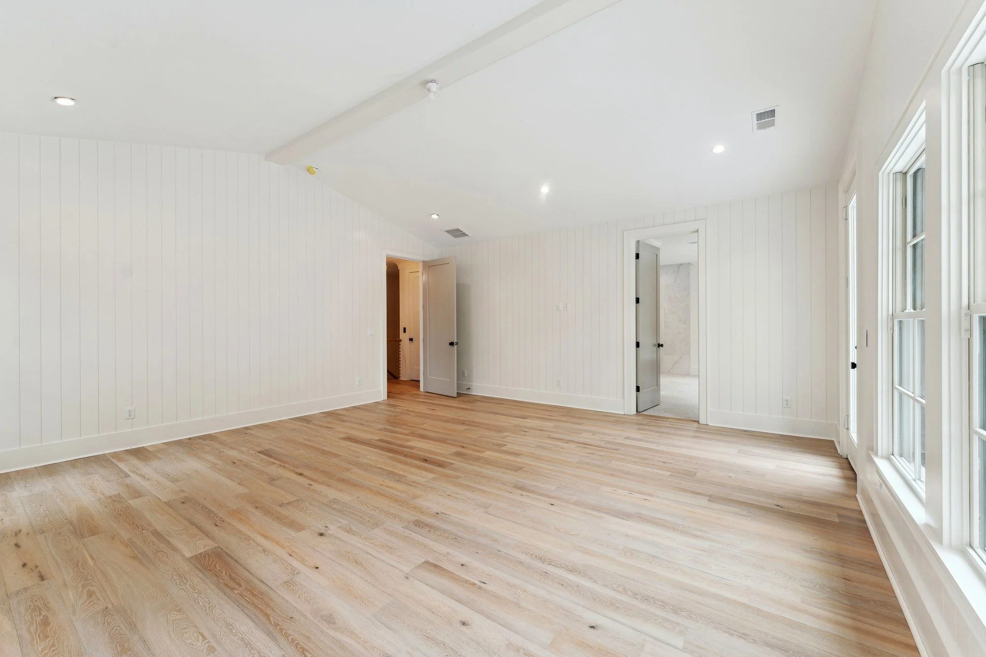 Bedroom with a vaulted ceiling and shiplap walls.