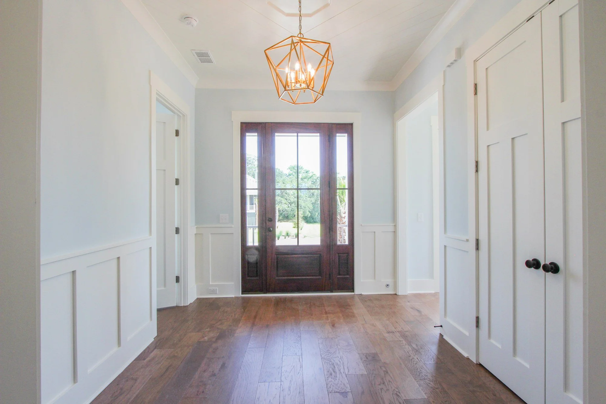 Entry hall with brass lantern and heart pine flooring in a Charleston SC custom home