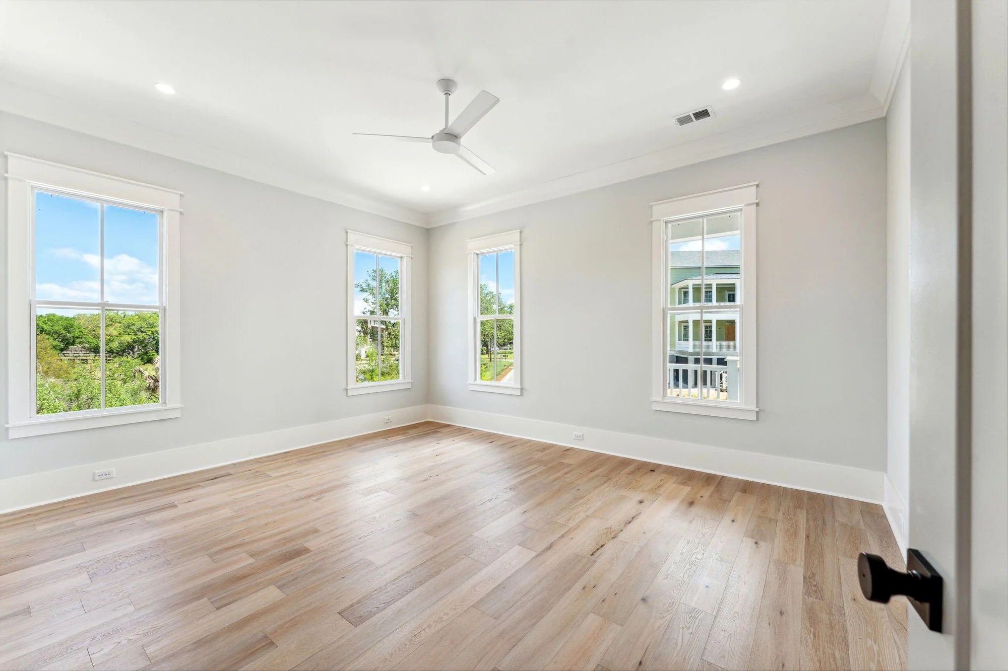 Bedroom with marsh-facing windows in a waterfront Daniel Island SC custom home build