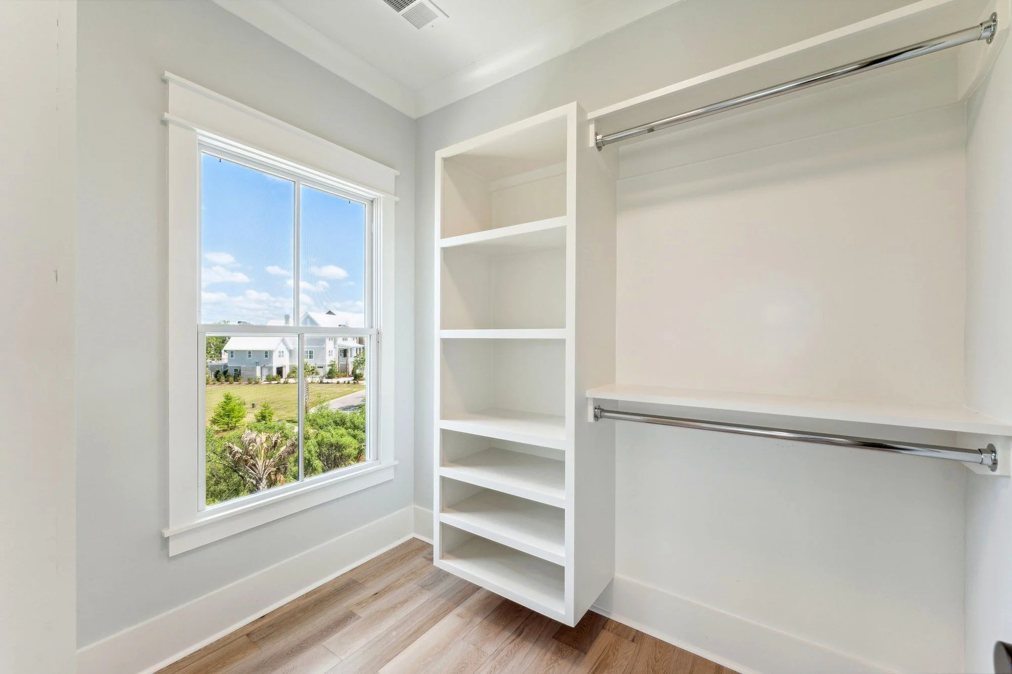 Custom primary walk-in closet with built-in shelving in a Daniel Island SC luxury home