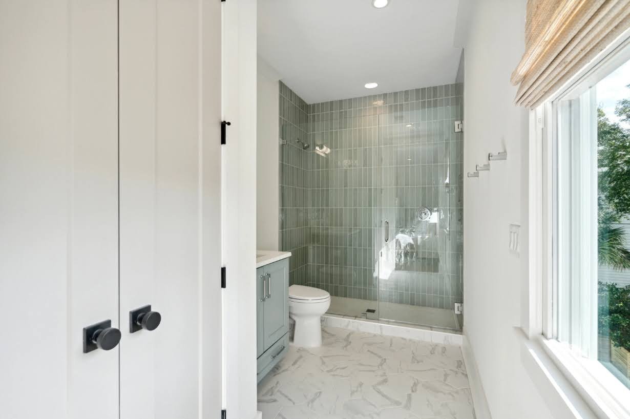 Guest bath with green tile shower surround in an Isle of Palms SC custom home build