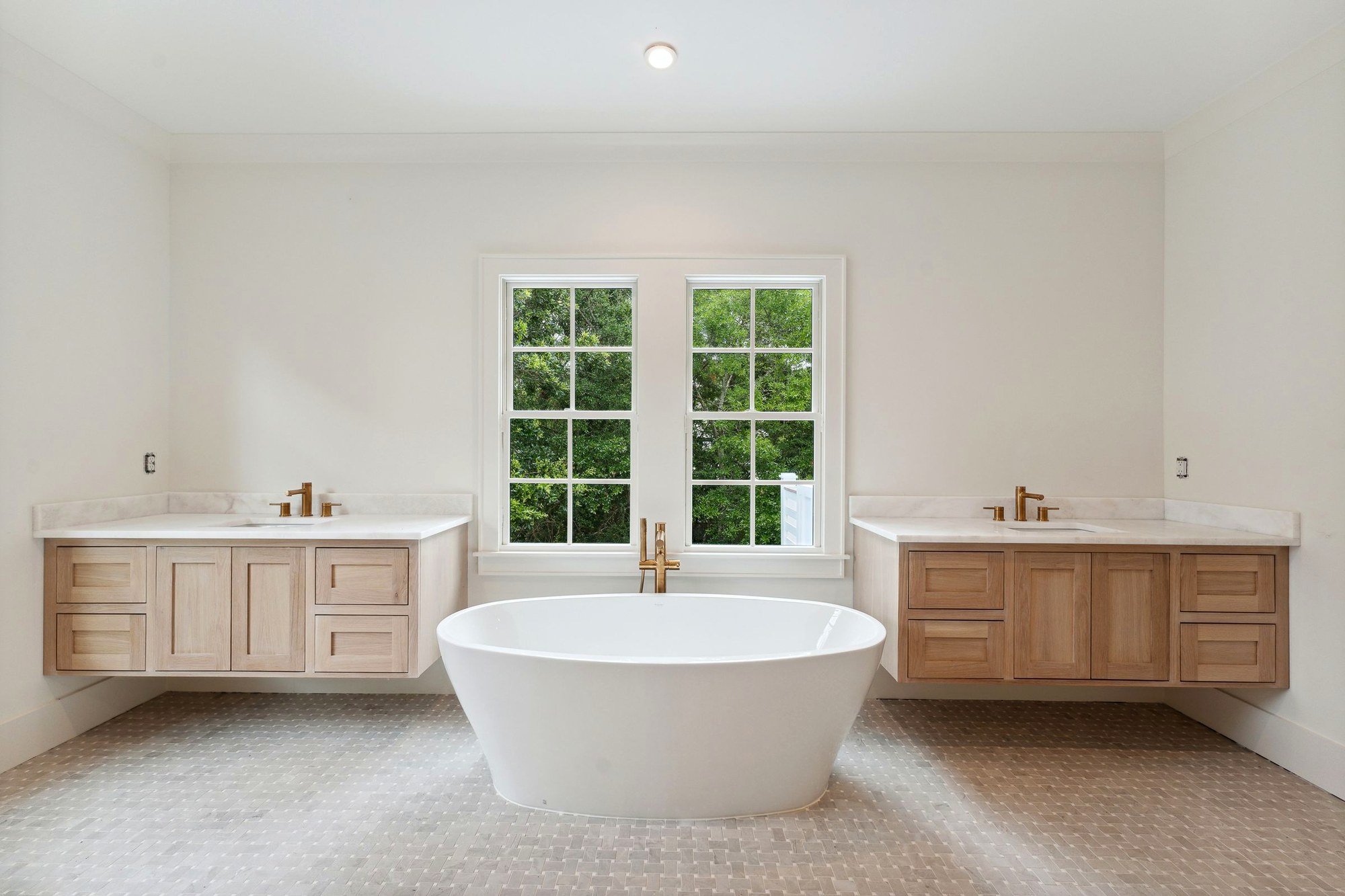 Freestanding soaking tub with brass fittings in the owner's bath.