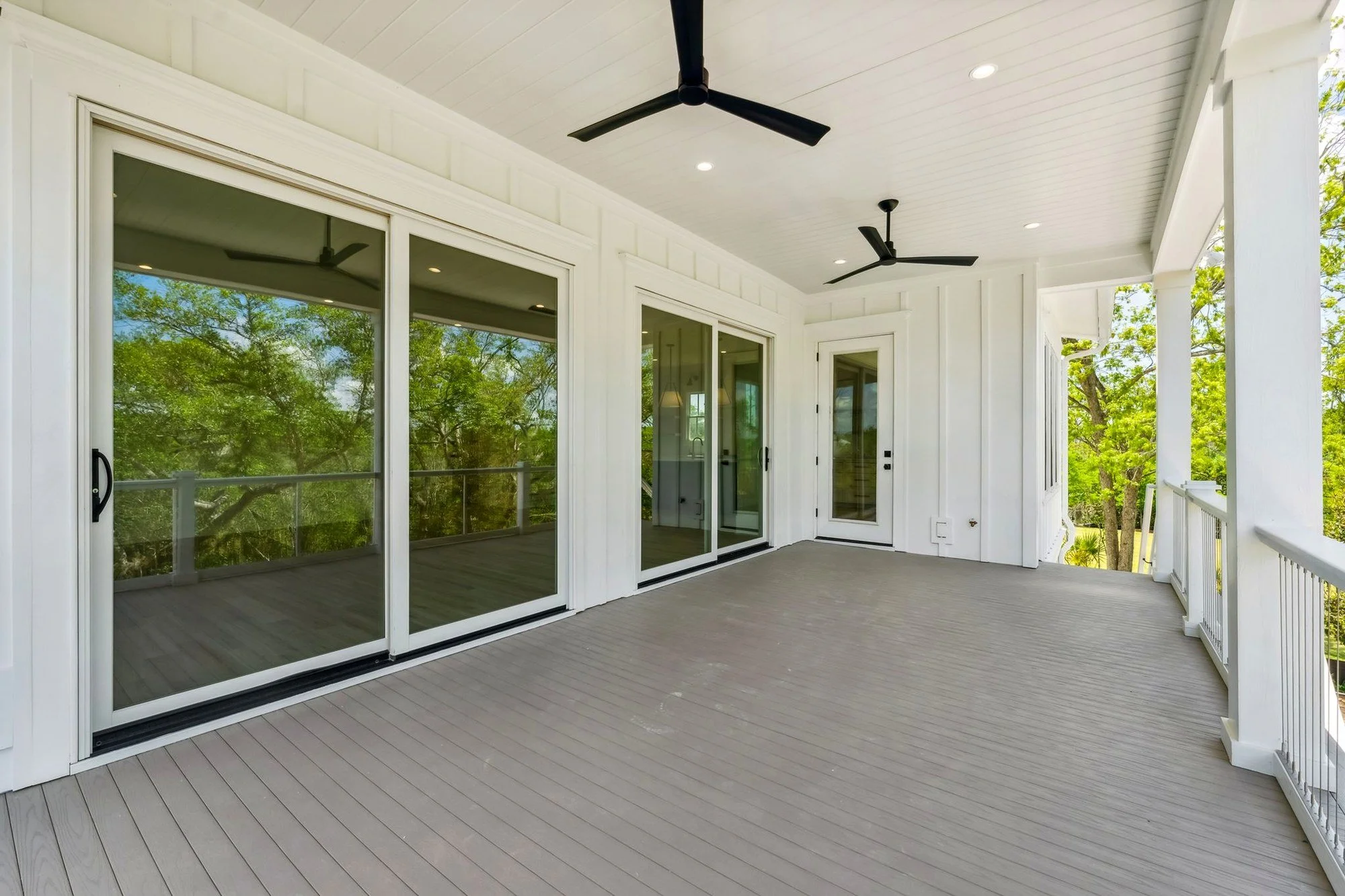 Elevated screened porch with sliding glass doors overlooking Daniel Island marshland