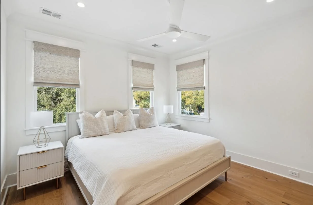 Guest bedroom with corner windows and coastal light on an Isle of Palms SC custom build