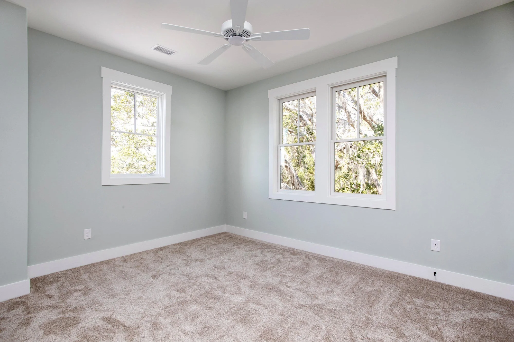 Guest bedroom with plush carpet and a ceiling fan in a Johns Island SC custom home