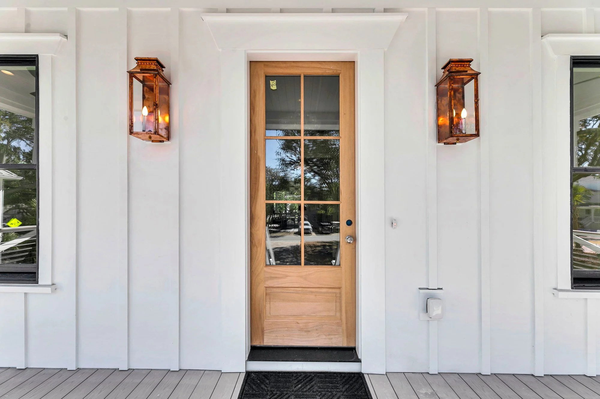 Mahogany front door framed by copper gas lanterns on an Isle of Palms SC custom home