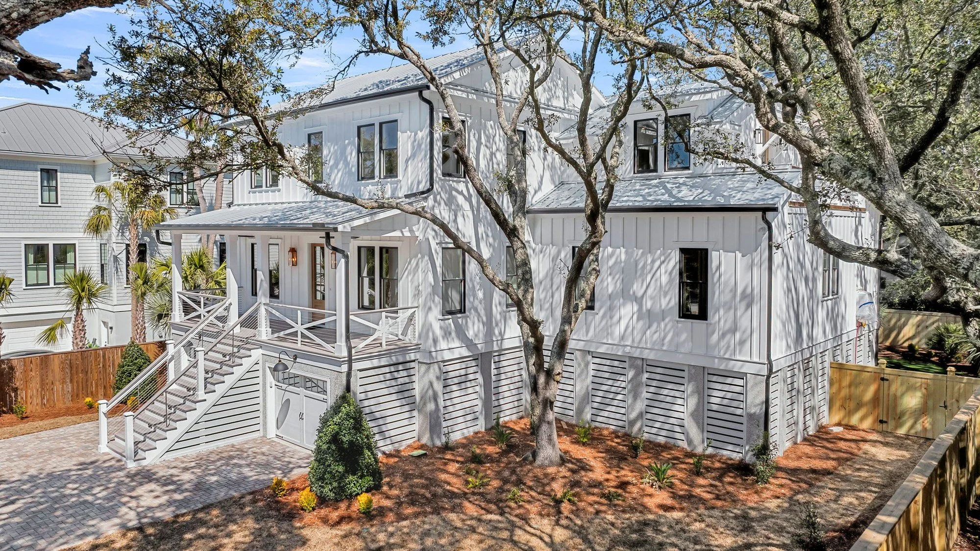 Live oak shaded side elevation of a coastal custom home built on Isle of Palms SC