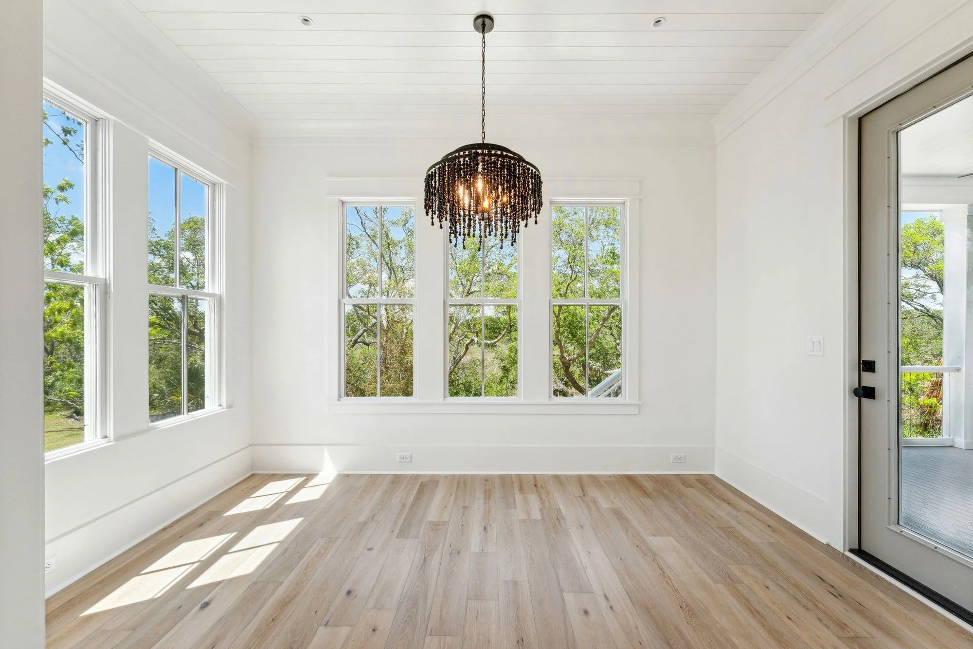 Breakfast room with beaded chandelier and porch access in a Daniel Island SC custom home