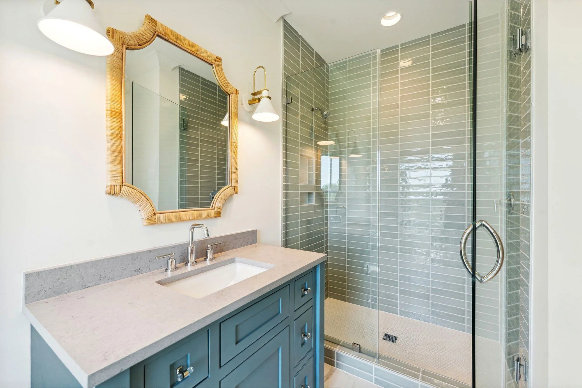Guest bath with stacked green tile shower and teal vanity in a Daniel Island SC home