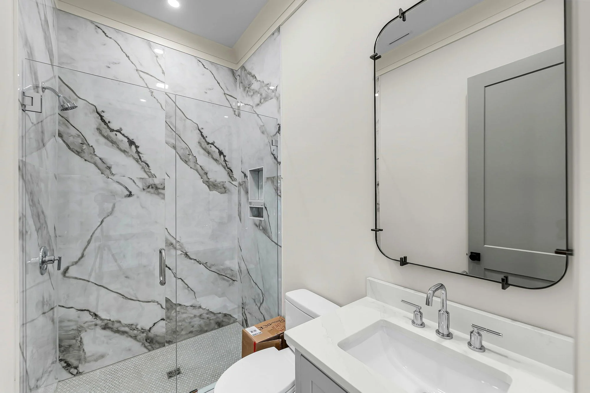 Powder room with marble slab vanity wall in a Charleston SC luxury custom home build
