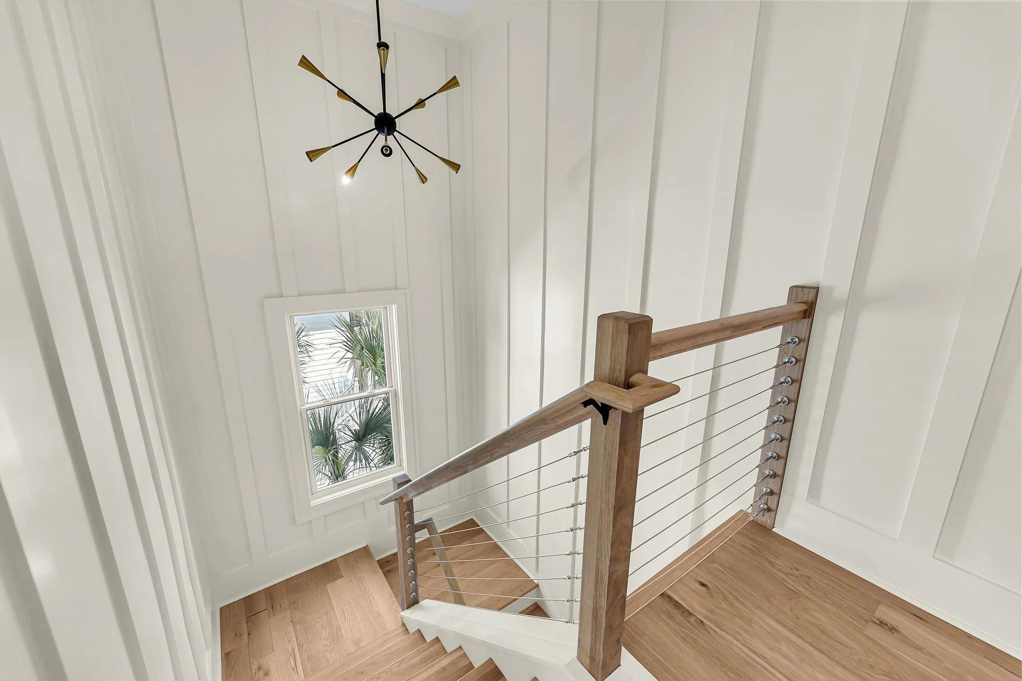 White oak stair landing with cable railing in a modern coastal Charleston SC custom home